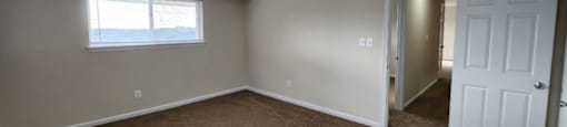 A room with brown carpet and white walls.