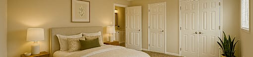 A bedroom with a large bed and a carpeted floor.