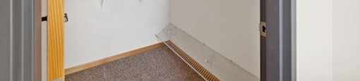 the closet in  bedroom with white walls and a wooden door