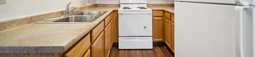 A kitchen with wooden cabinets and a white refrigerator.