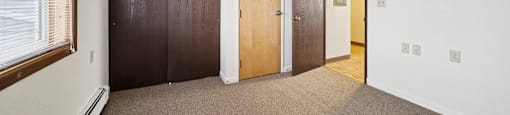 A room with brown carpet and white walls.
