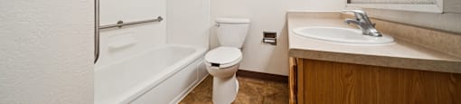 A white bathroom with a toilet, sink, and bathtub.