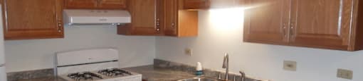 Kitchen with a white stove and wooden cabinets.at The Countryside, Countryside, IL 60525 ?