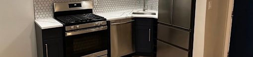 A kitchen with appliances and white cabinets at Evelyn Apartments, Oak Park, IL