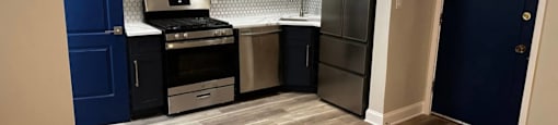A kitchen with a blue door and a stove top oven at Evelyn Apartments, Oak Park, Illinois