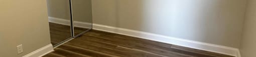 A room with a wooden floor and a mirrored closet at Evelyn Apartments, Oak Park