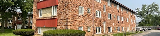 A red brick apartment building with a green lawn in front.at The Countryside, Illinois, 60525?