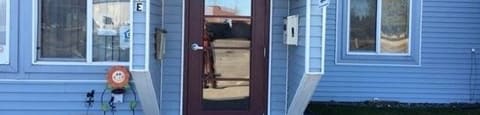 a front door of a house with snow on the ground at Woodridge Apartments, Kenai, 99611