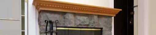 a stone fireplace in a living room with a wood floor at The Bryant at Oak Park I & II, Oak Park, IL 60302