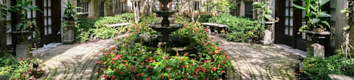 a courtyard with a fountain and flowers in front of a building at The Bryant at Oak Park I & II, Oak Park