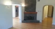 living room with a fireplace and a ceiling fan at Bryant II