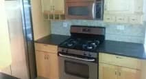 a kitchen with a stove and a microwave and a refrigerator at Bryant II
