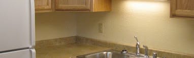 a kitchen with a sink and a refrigerator at Conifer Woods Apartments, Homer, AK, 99603