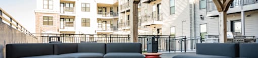a patio with couches and a fire pit on a