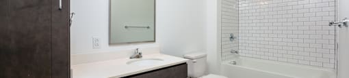 A bathroom with a white sink and a white toilet.