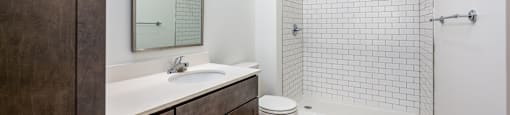 A bathroom with a white sink and a white toilet.