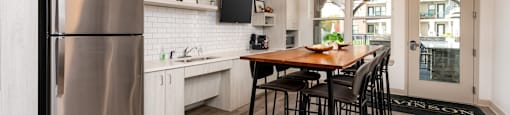 A modern kitchen with a wooden table and chairs.