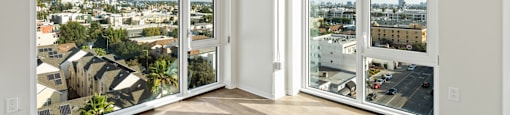 A room with a view of the city through large windows.