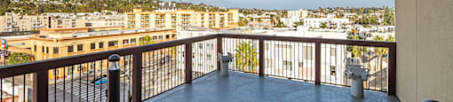 A balcony with a metal railing overlooks a cityscape.