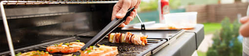 a man grilling food on a grill at Morea Apartments, Pompano Beach, FL