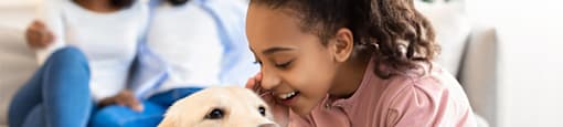 a girl playing with a dog with her family in the background at Morea Apartments, Florida, 33062
