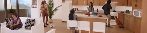 A group of people are gathered in a modern kitchen and living room.