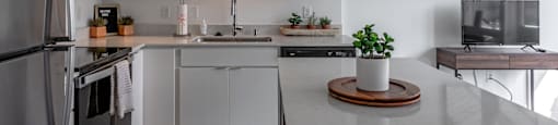 a kitchen with white cabinets and a marble counter top