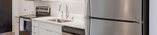 a kitchen with stainless steel appliances and white cabinets