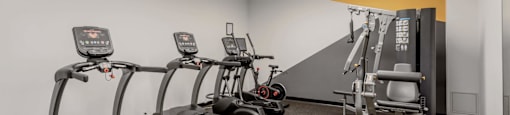a gym with cardio equipment and weights in a building