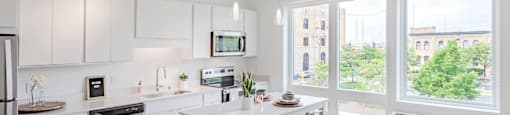 a large white kitchen with a large window