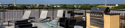 the outdoor patio has a grill and a table with chairs on it
