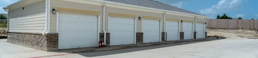 A building with a grey roof and white garage doors.