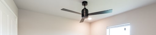 A room with a ceiling fan and a window.