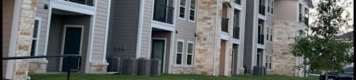 exterior view of agave east apartment buildings with stone and gray walls