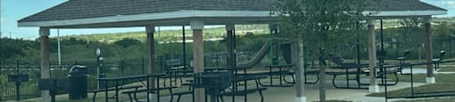a pavilion with picnic tables at agave east apartments in del valle, tx