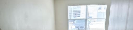 Empty room with a large window at Canterbury House apartments in Monticello, Indiana