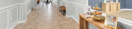 A long hallway with a bench and a box on a table.