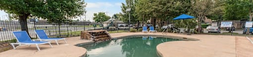 A small pool with a slide and a fence.
