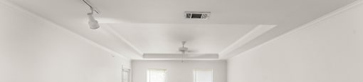 A spacious room with carpeted floor and white walls.