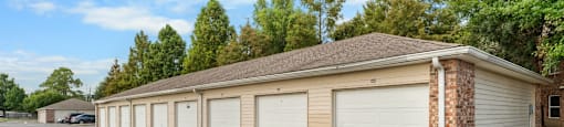 A long garage with a brick pillar in front.
