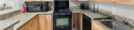 A kitchen with wooden cabinets and granite countertops.