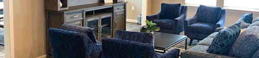 A living room with a dark blue couch and a wooden floor.