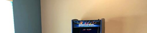 A foosball table is in a room with a video game machine.