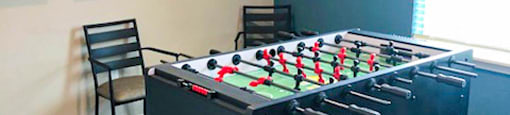 A foosball table in a small room with pictures on the wall