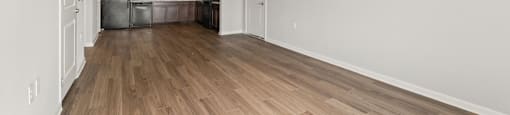 A room with a ceiling fan and wooden flooring.