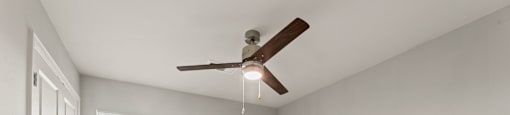 A room with a ceiling fan and a window.