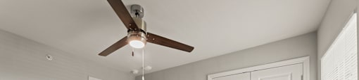 A room with a ceiling fan and two doors.