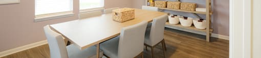 A dining room with a table and chairs.