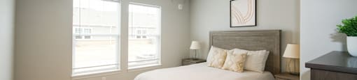 A bedroom with a bed, nightstand, and a ceiling fan.