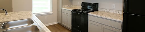 A kitchen with black appliances and white cabinets.